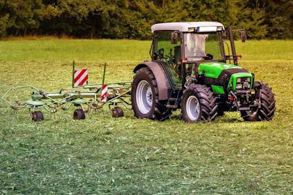 Traktor finansiert av næringskreditt, driftskreditt i Luster Sparebank køyrer på ei mark. Foto