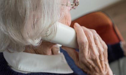 Eldre kvinne snakker med mulig svindler i telefonen. Foto